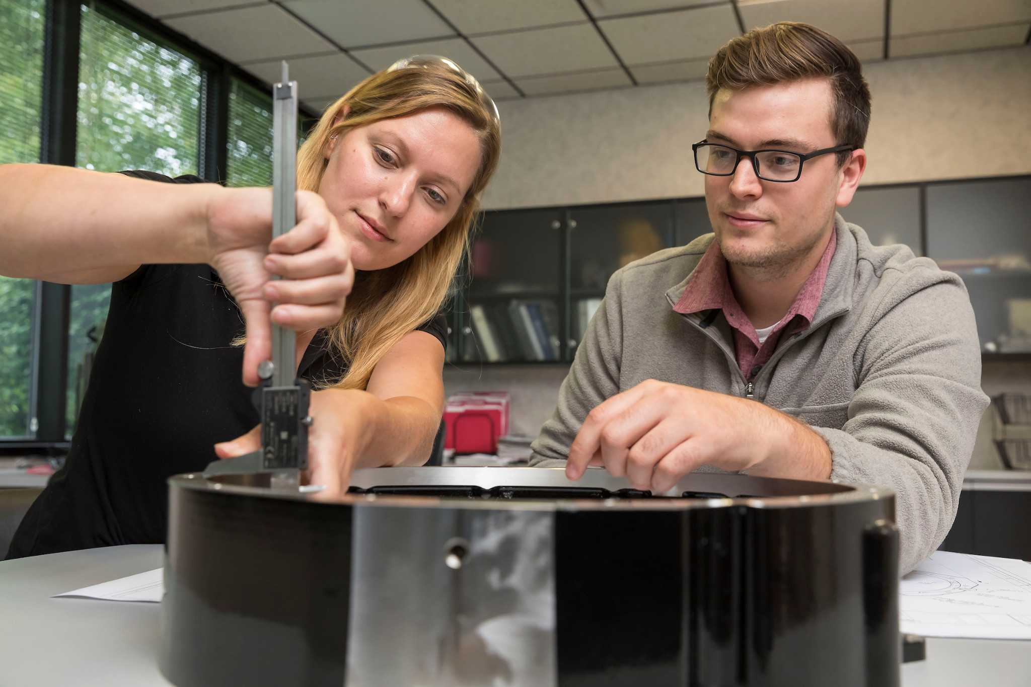 a woman and man work on component